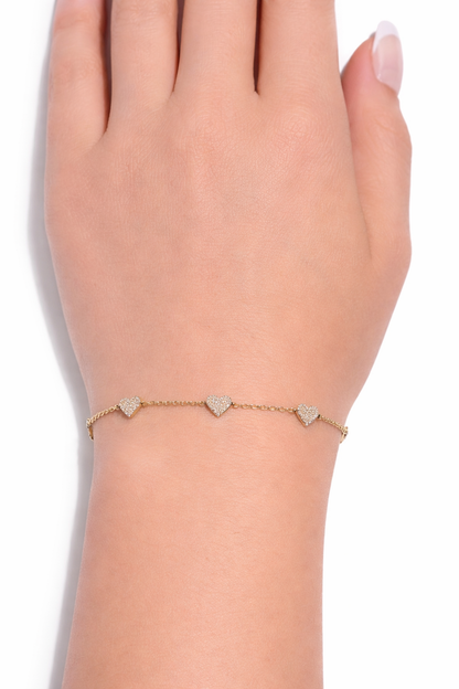14k yellow gold diamond heart station bracelet worn on wrist with pavé diamonds in Huntington Beach Orange County