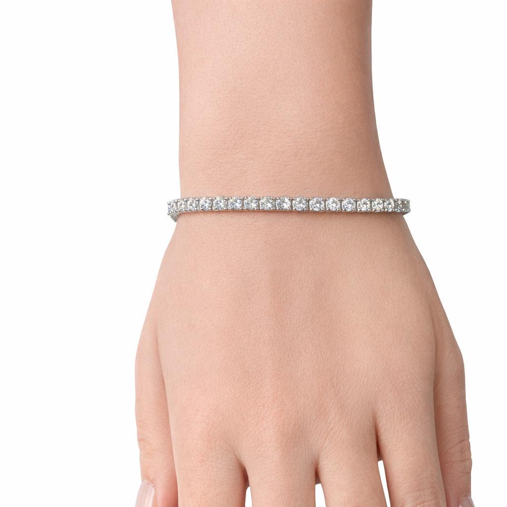 White gold round diamond tennis bracelet worn on wrist on white background