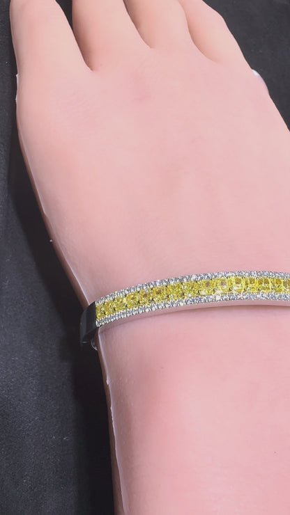 Close up video of 14K white gold bangle bracelet with yellow center diamonds and white diamond halo on wrist Isabella’s Fine Jewelry Huntington Beach Orange County