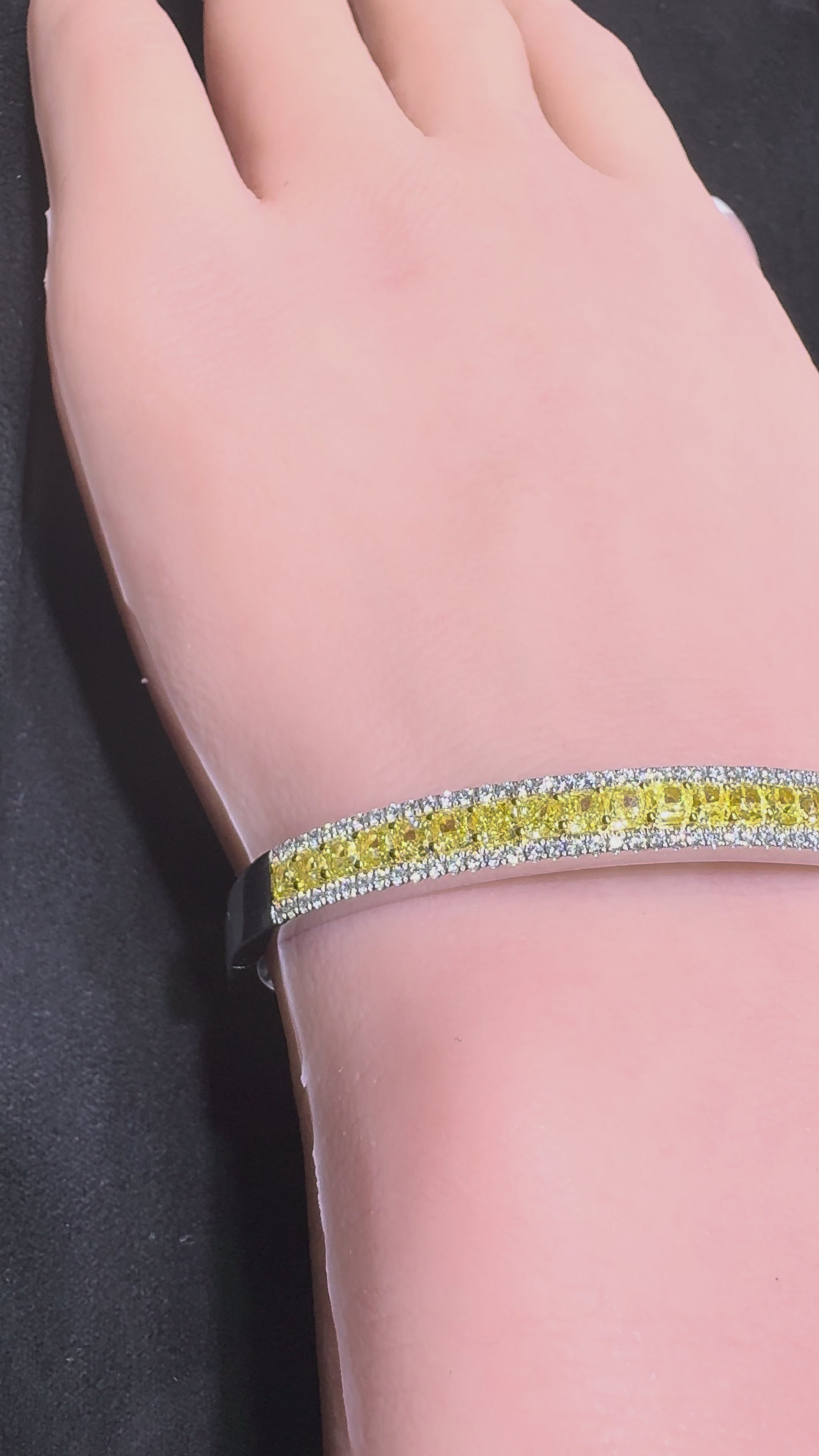 Close up video of 14K white gold bangle bracelet with yellow center diamonds and white diamond halo on wrist Isabella’s Fine Jewelry Huntington Beach Orange County