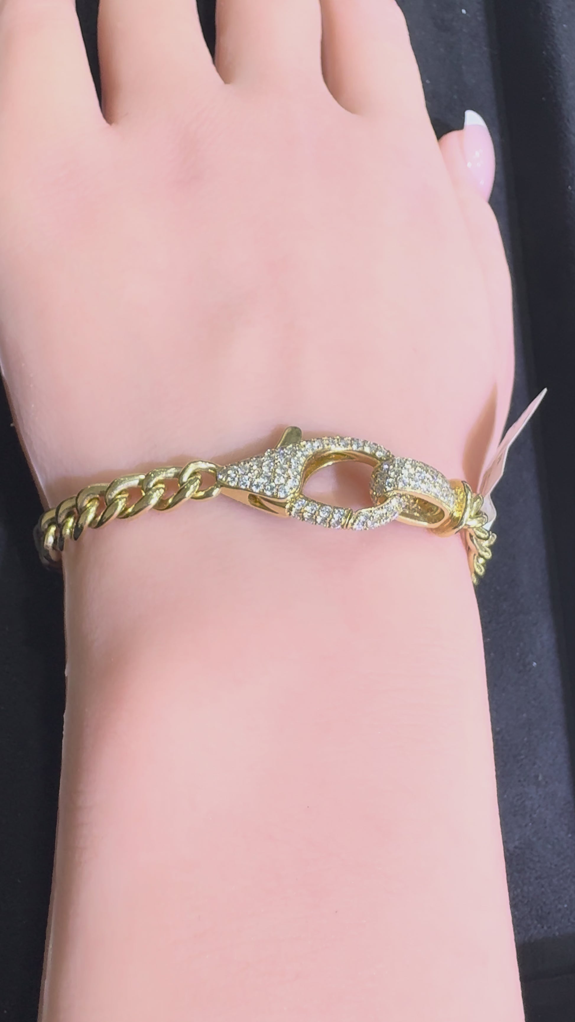 Video of a 14KT yellow gold Cuban link bracelet featuring a diamond lobster clasp worn on wrist highlighting natural diamond sparkle and polished gold links